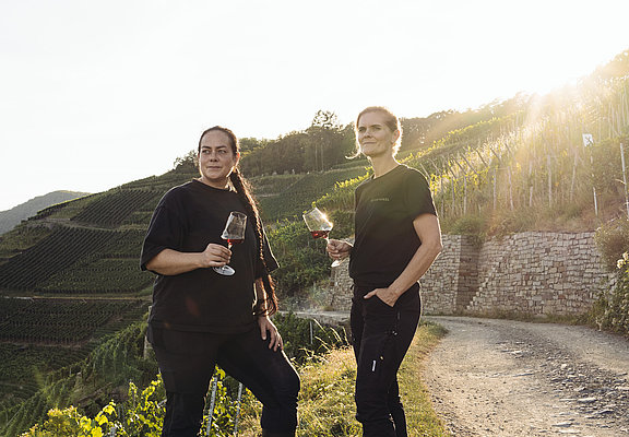 Weinprobe im Weingut Meyer-Näkel in Dernau mit Ausblick auf die terrassierten Weinberge und Sonnenuntergang.