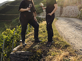 Weinprobe im Weingut Meyer-Näkel in Dernau mit Ausblick auf die terrassierten Weinberge und Sonnenuntergang.